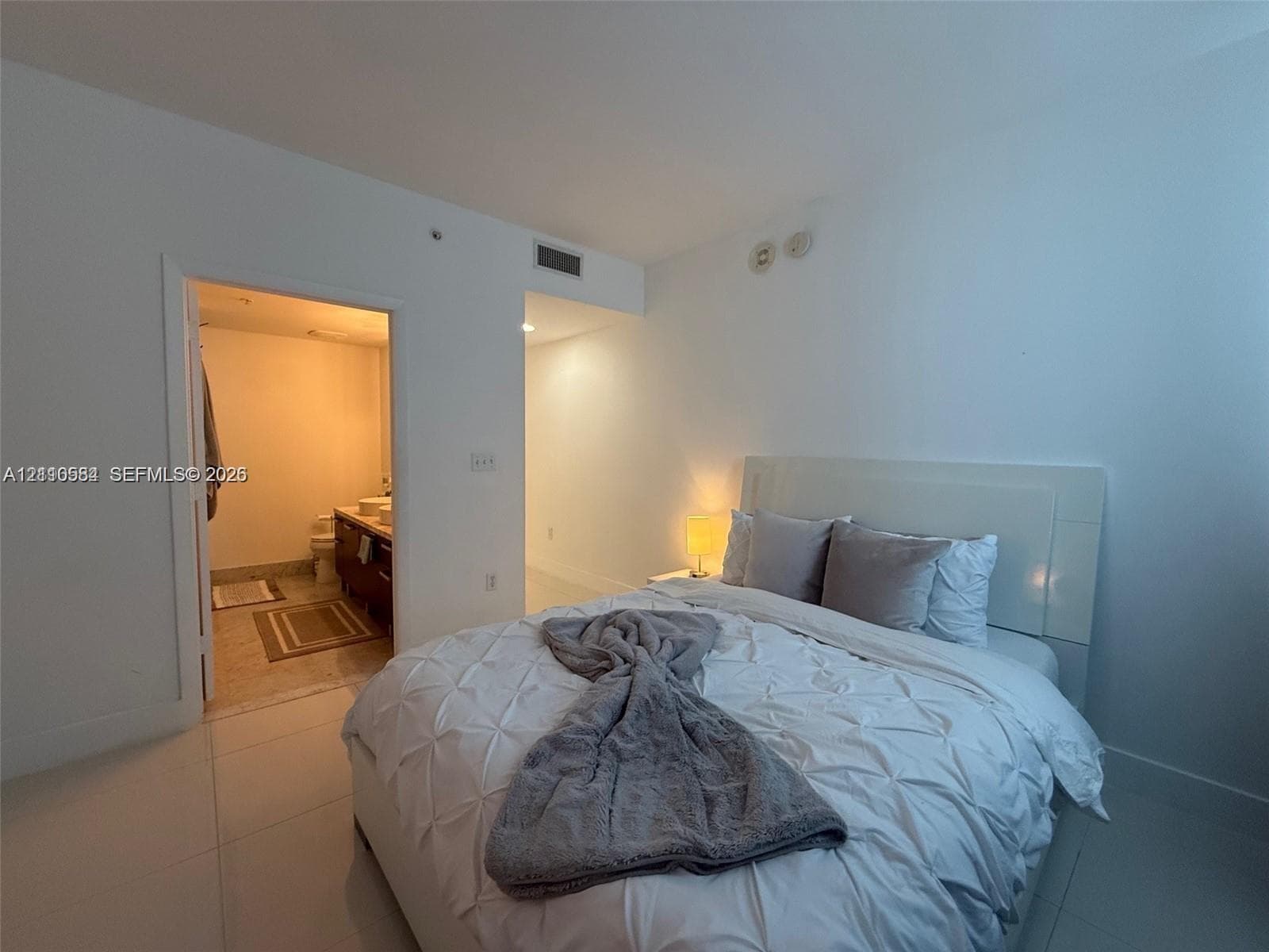 Neutral wall palette featuring large-format tile flooring and overhead recessed lighting