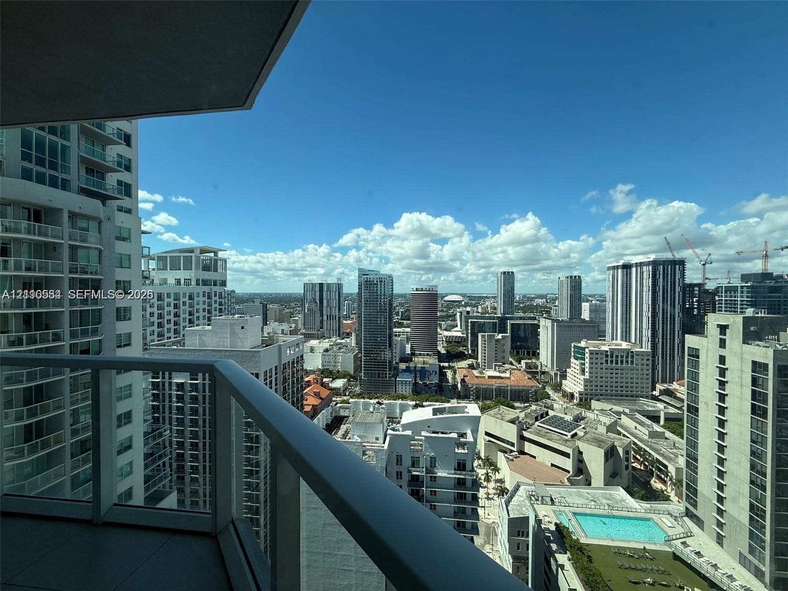 Private balcony featuring glass railings and panoramic cityscape scenery