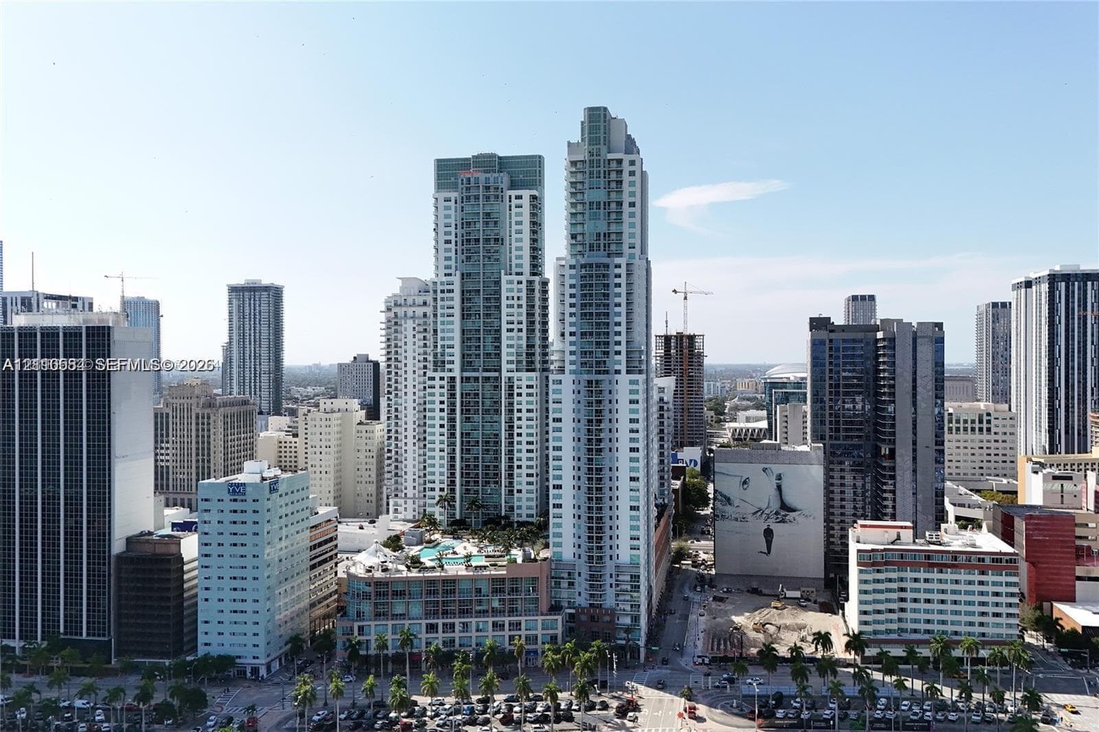 High-rise urban landscape featuring glass-facade towers, balconies, and street-level palm tree landscaping