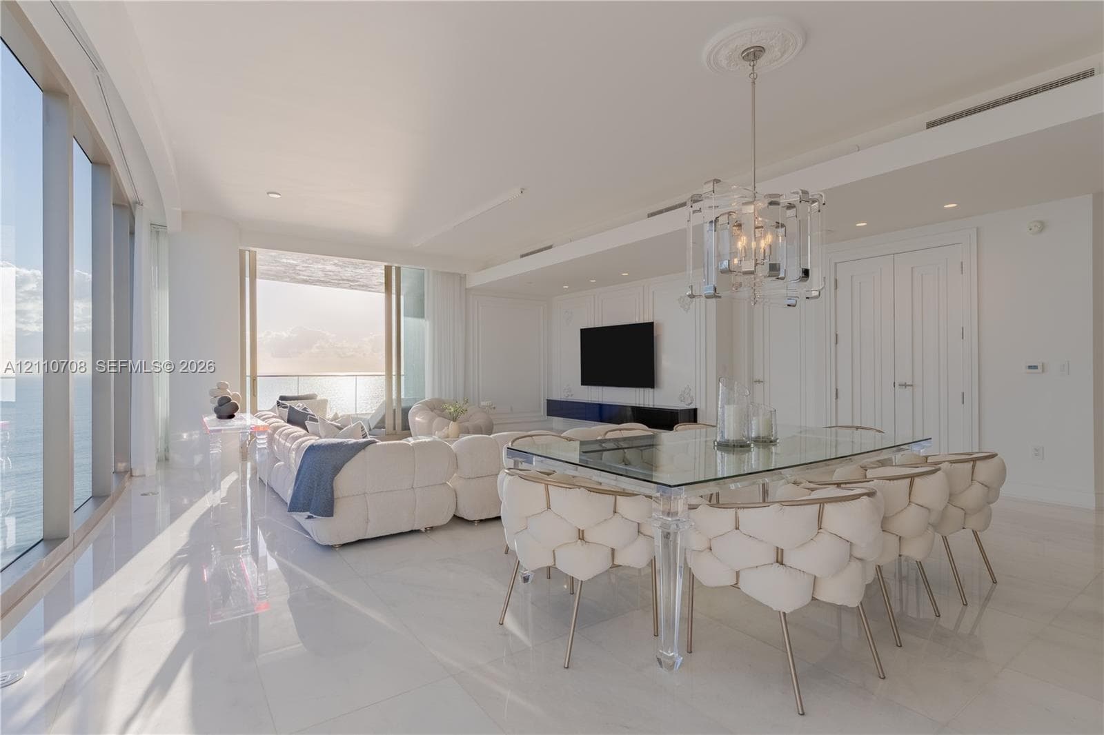 Lobby featuring a white sculptural reception desk, recessed ceiling lighting, glass-panel entry doors, and high-gloss flooring