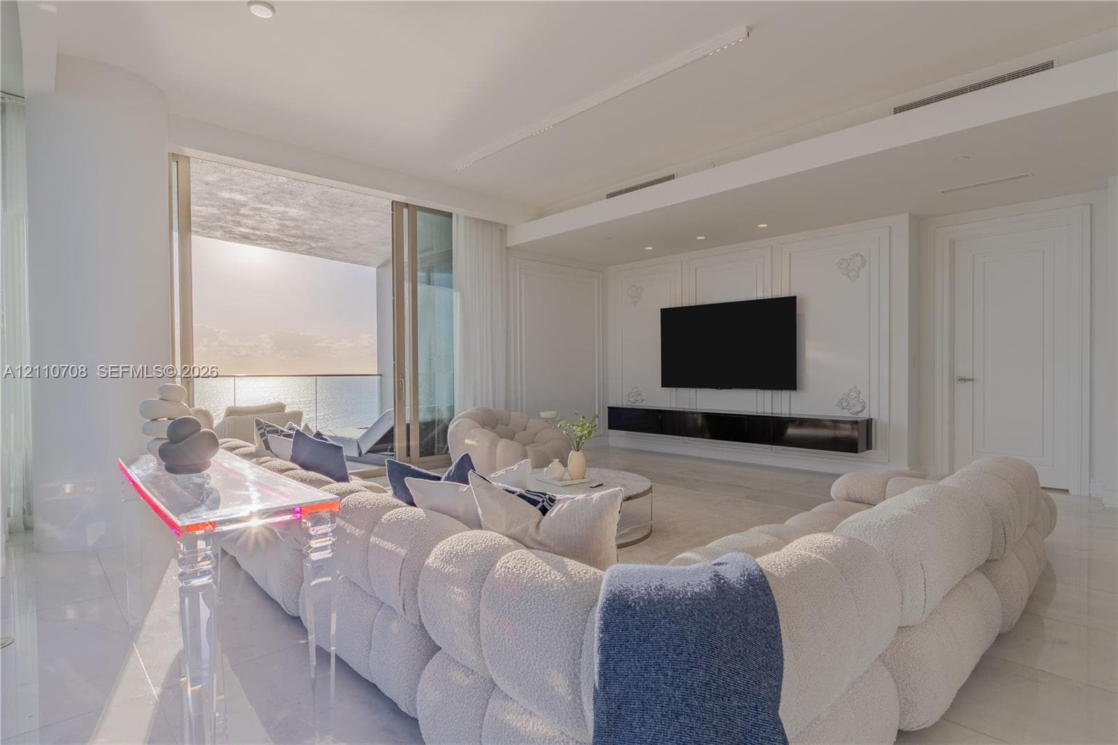 Expansive interior space featuring a geometric reception desk, integrated ambient cove lighting, recessed ceiling fixtures, built-in recessed seating benches, and gradient wall finishes