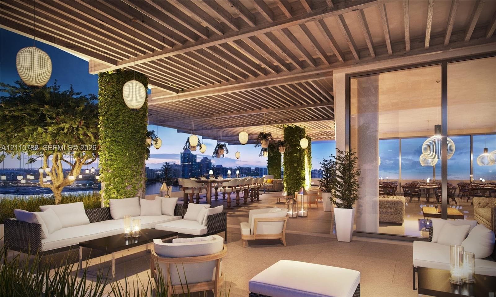 Mid-rise architectural exterior featuring tiered glass balconies, floor-to-ceiling windows, white structural columns, a circular paved motor court, and waterfront landscaping