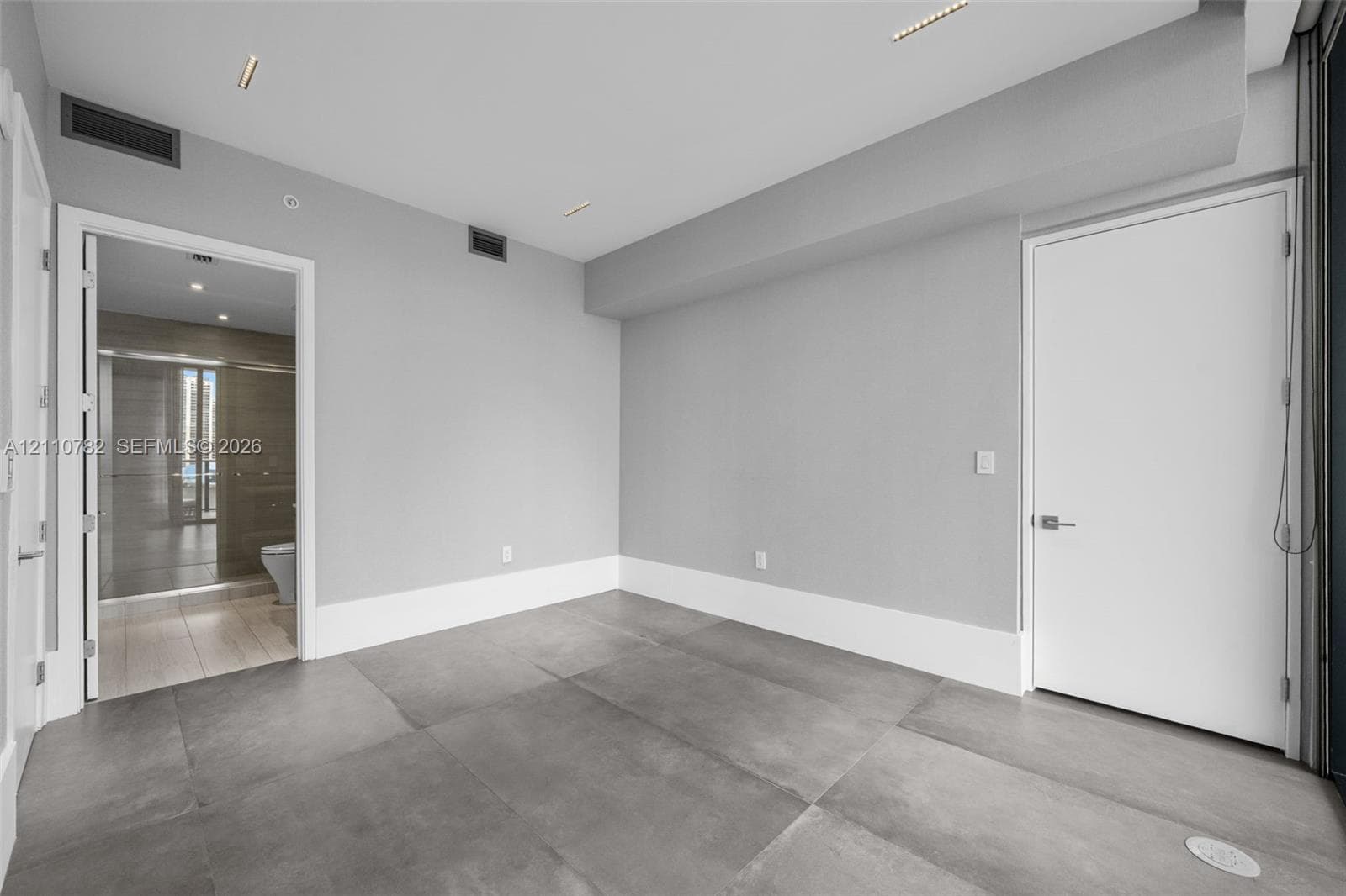 Large-format white tile with grey veining, glass-enclosed walk-in shower with rainfall showerhead, and a deep-soaking drop-in bathtub