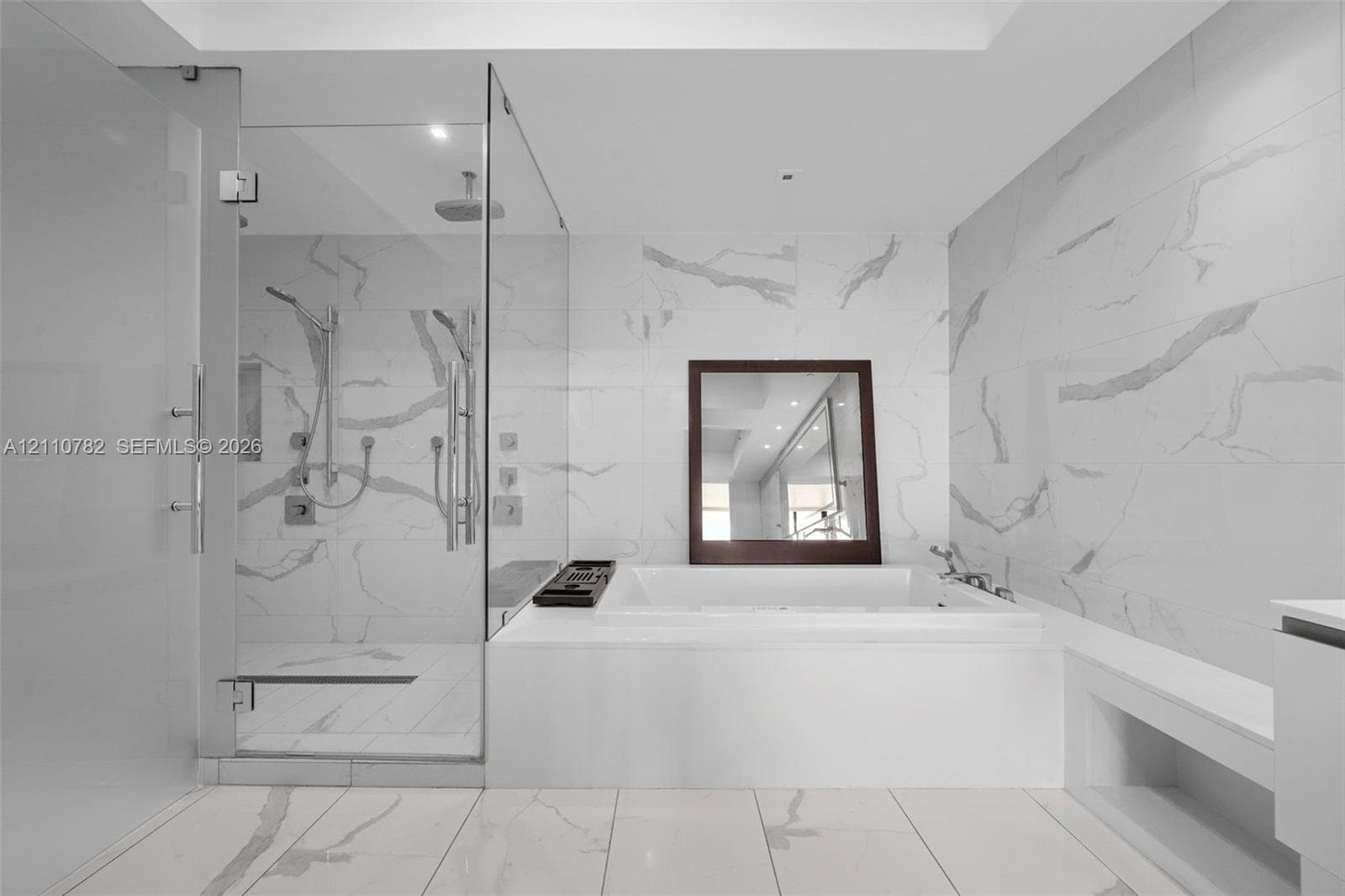 Floating dual vanity with integrated sinks, large-format stone-finish tile flooring and wall cladding, recessed lighting, and expansive wall-to-wall vanity mirror