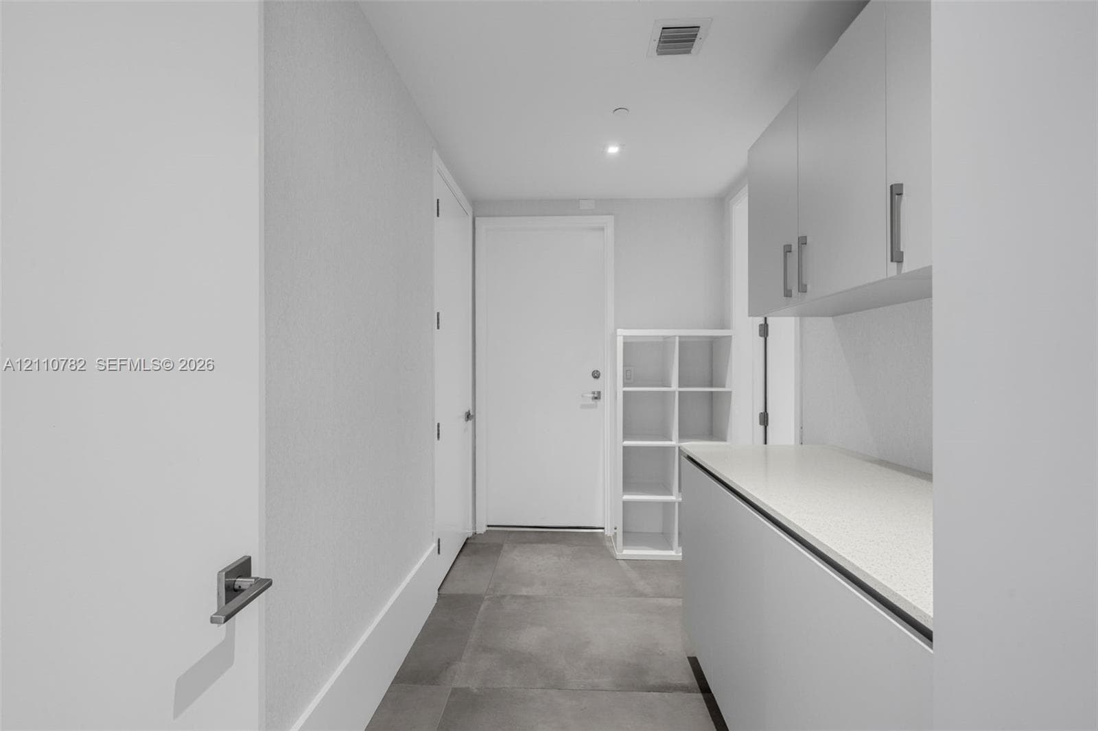 Bathroom featuring a glass-enclosed walk-in shower with tile surround, vanity with a light-tone wood finish, solid-surface countertop, and an integrated rectangular basin