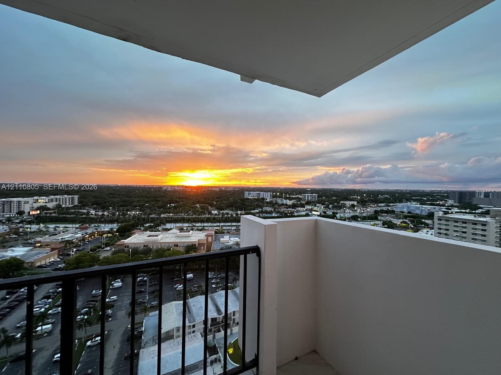 Private balcony featuring black metal railings and overhead coverage, showcasing expansive panoramic scenery