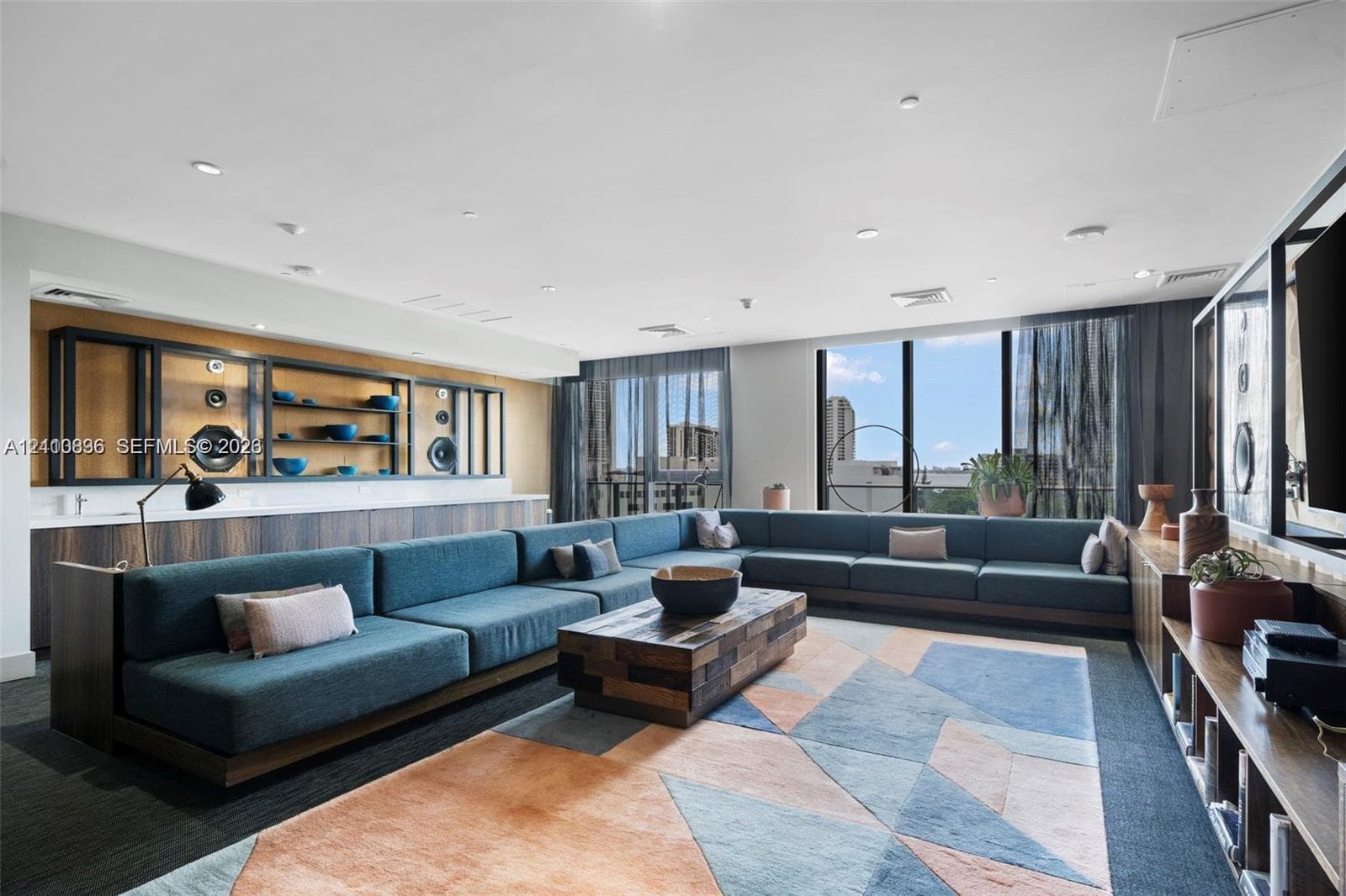 Expansive room featuring floor-to-ceiling windows, custom built-in dark wood cabinetry, recessed lighting, and integrated shelving units