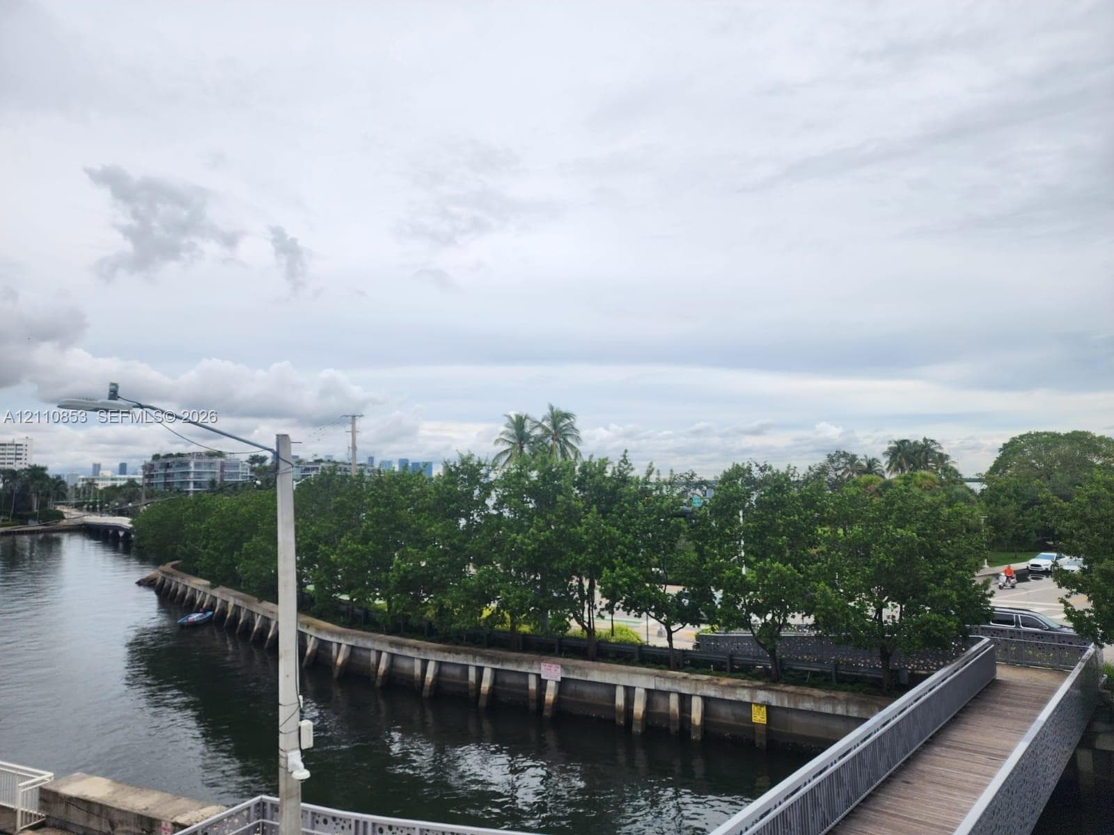 Waterfront bulkhead with an elevated pedestrian walkway featuring wood-finish decking and metal railings