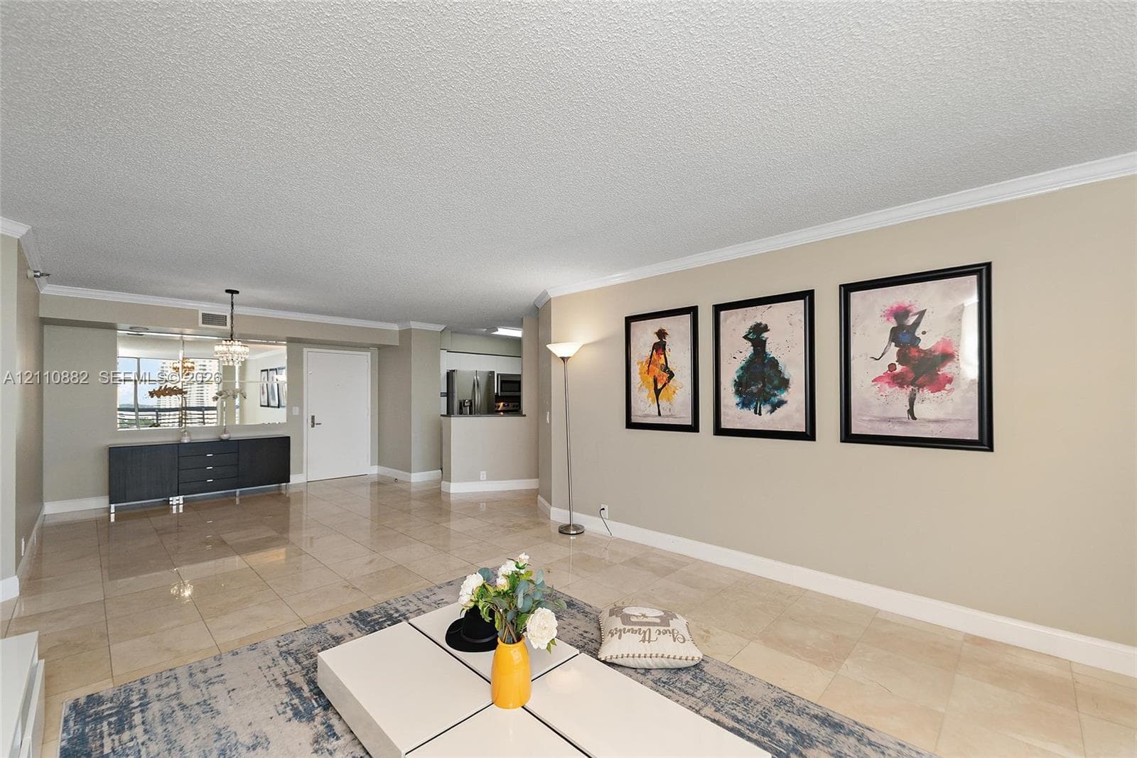 Polished tile flooring, crown molding, and a built-in wall-to-wall mirror
