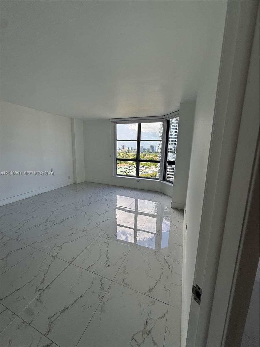 Large-format polished tile flooring, floor-to-ceiling windows with grid detailing, and panoramic urban scenery