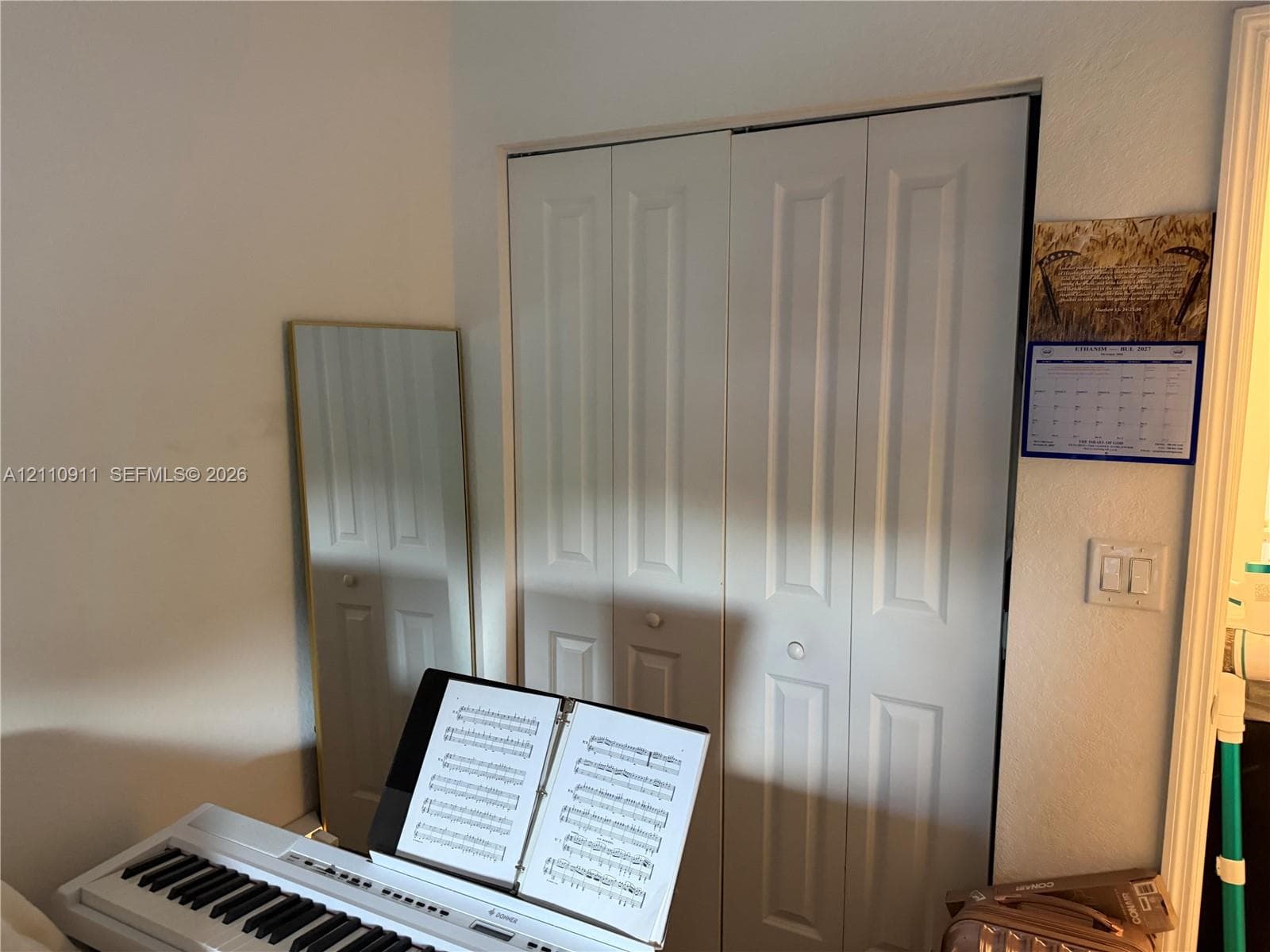 Room interior featuring neutral walls, a multi-textured window treatment with integrated roller shade, and a ceiling-mounted light fixture