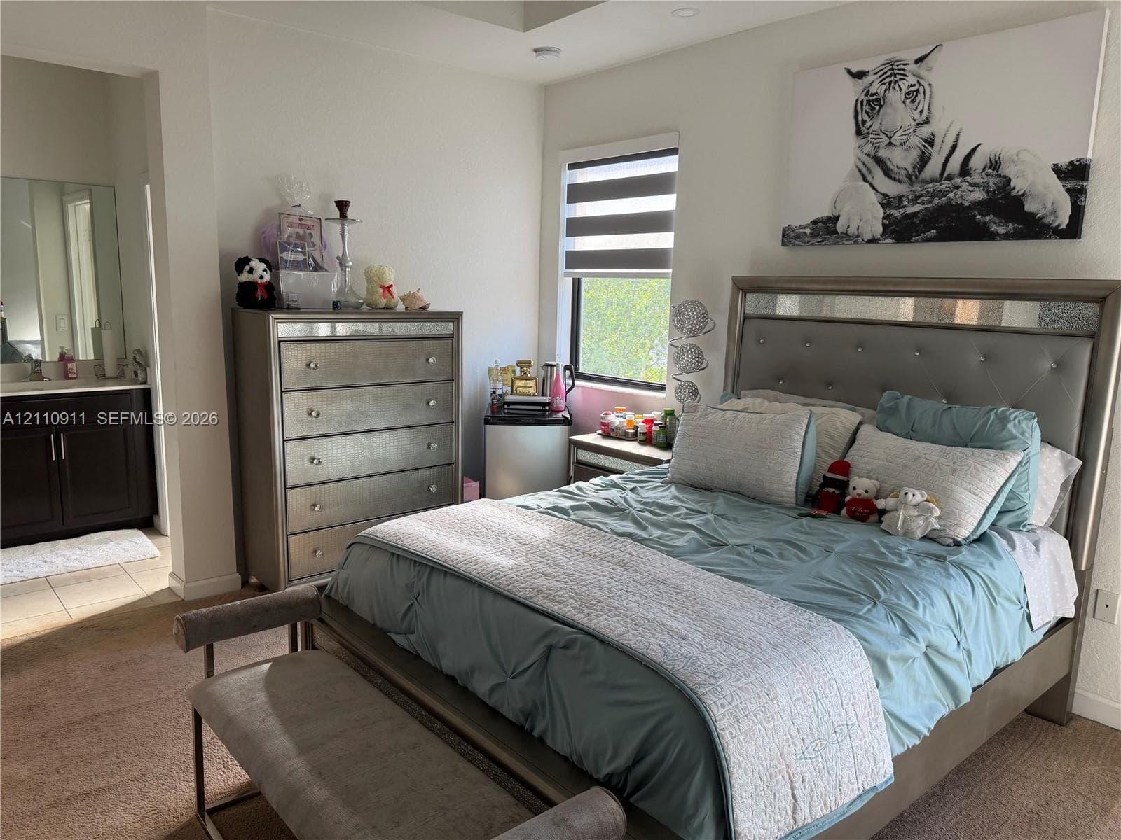 Neutral-toned interior featuring dual windows, tray ceiling, and wall-to-wall carpeting