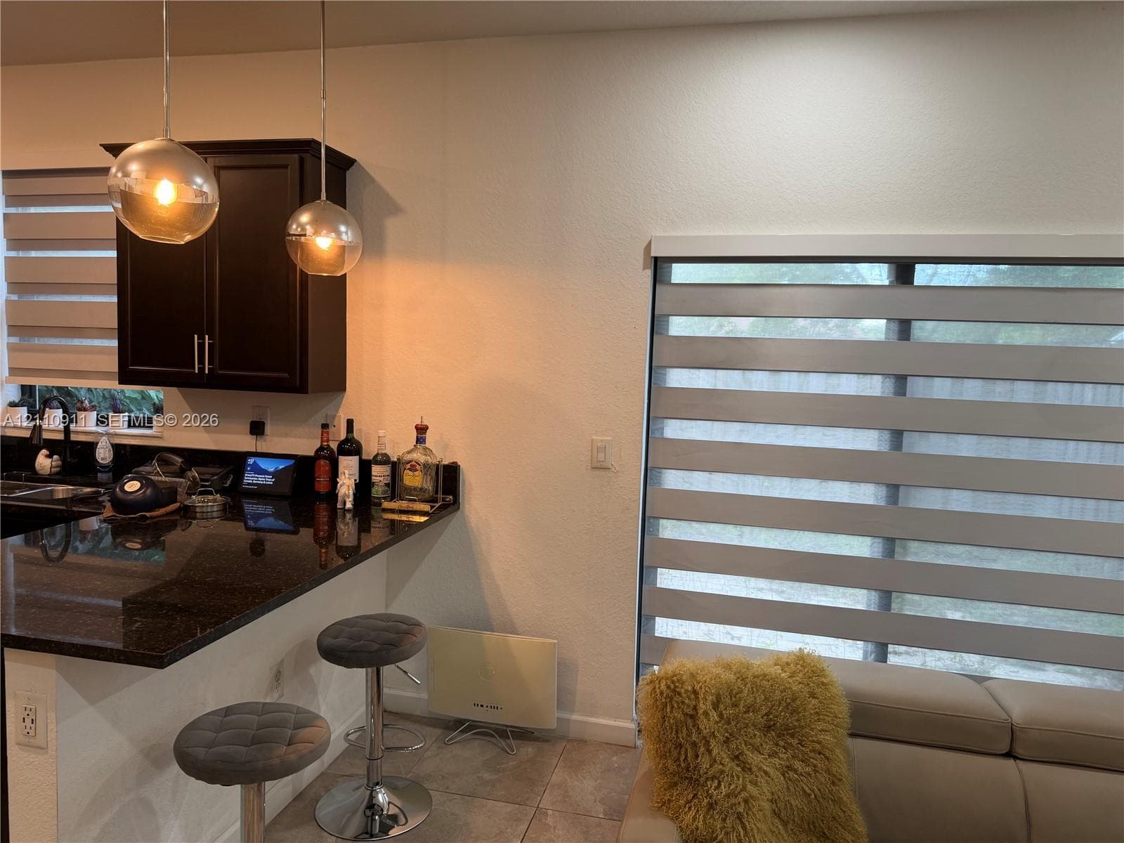 Sliding glass door featuring adjustable horizontal light-filtering shades and neutral tile flooring