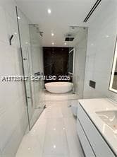 Freestanding soaking tub, glass-enclosed shower, wall-mounted vanity with integrated sink, and polished large-format tile flooring