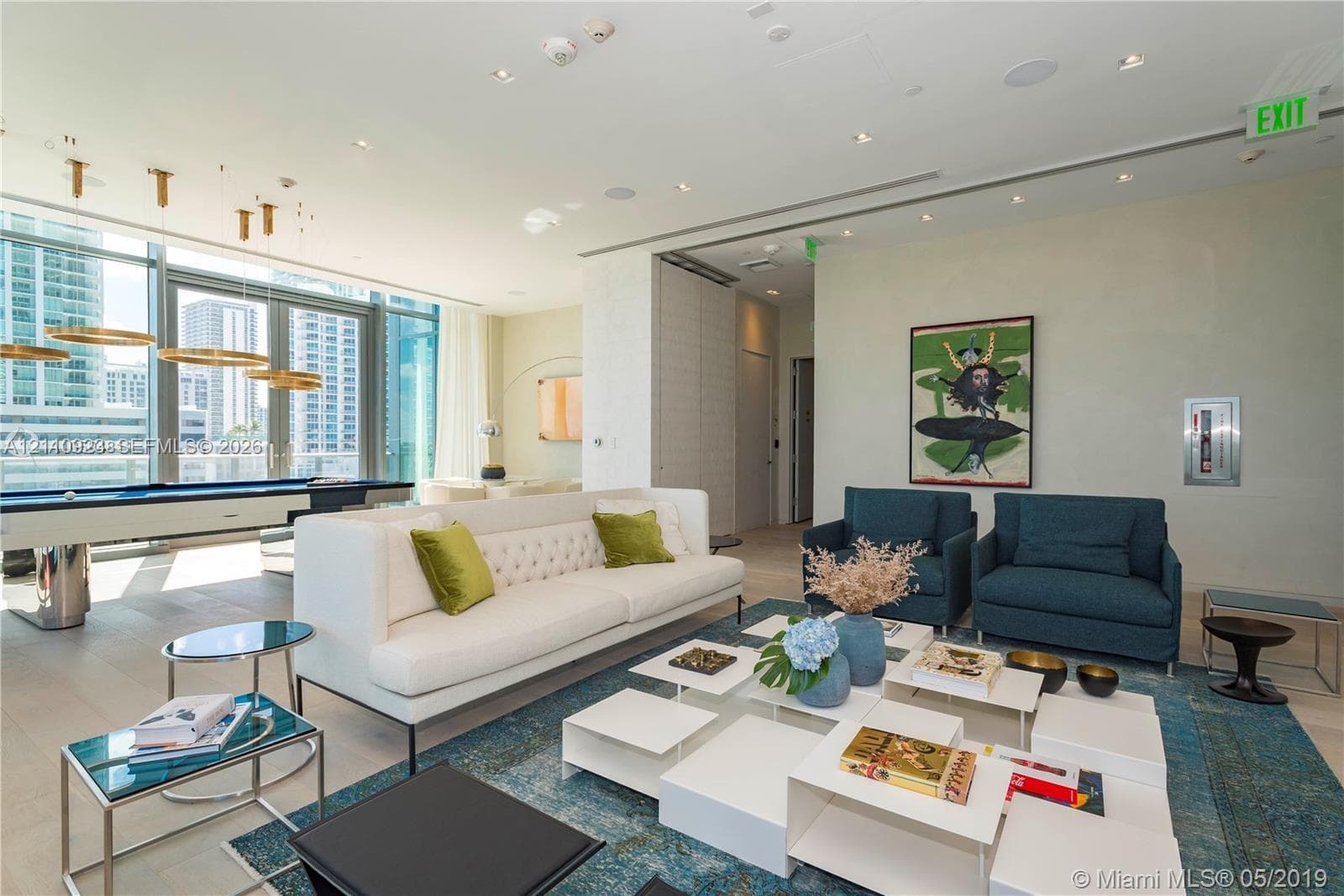Floor-to-ceiling glass windows, recessed ceiling lighting, circular pendant light fixtures, and wide-plank wood-finish flooring