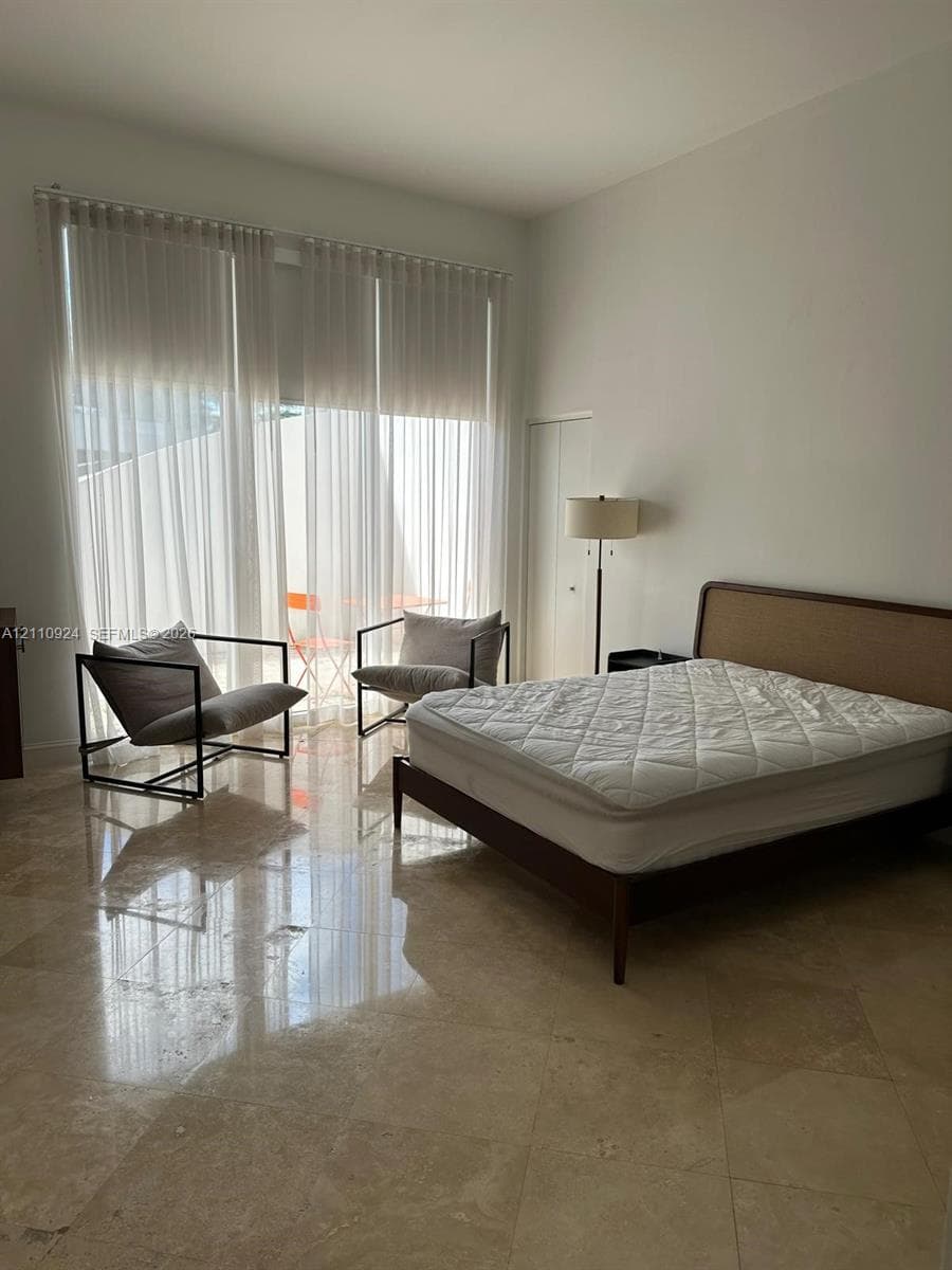 Polished stone flooring, expansive floor-to-ceiling windows, and recessed ceiling lighting