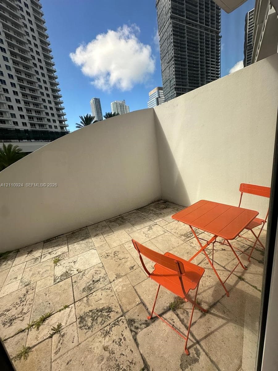 Private terrace featuring stone tile flooring and solid privacy walls