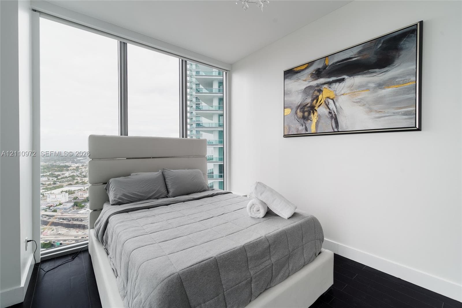 Floor-to-ceiling windows, dark wood-finish flooring, and recessed ceiling lighting