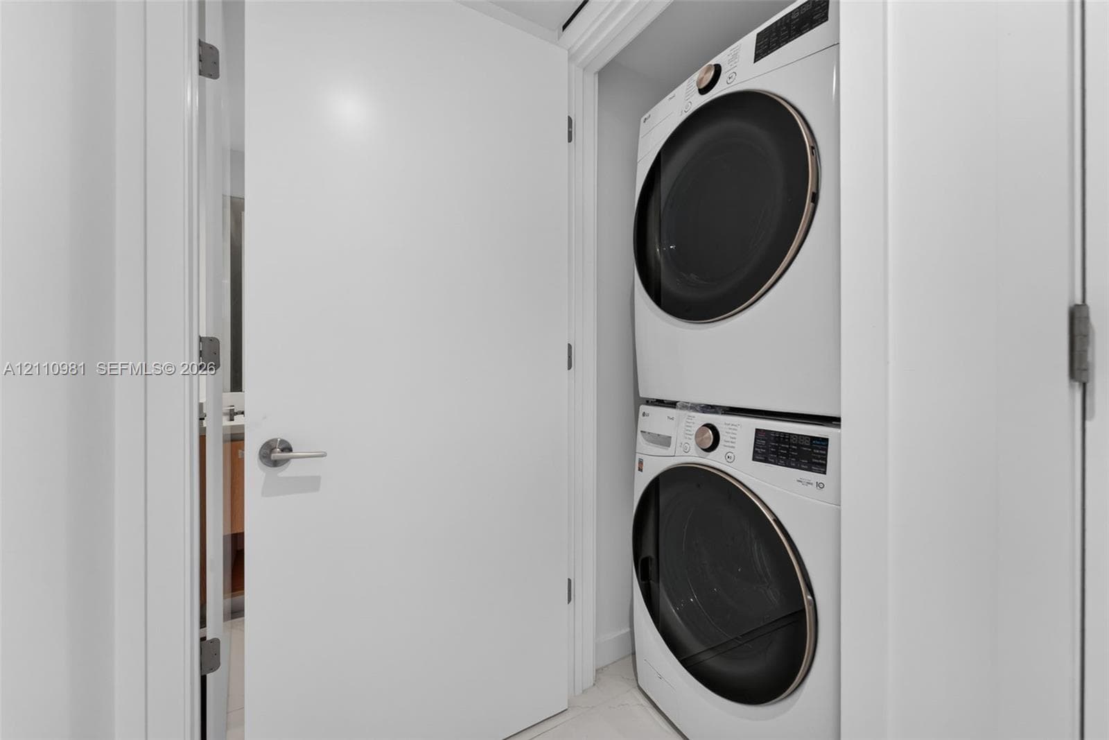 Stacked laundry unit featuring a high-efficiency front-load washer and dryer with circular glass doors and integrated digital control panels