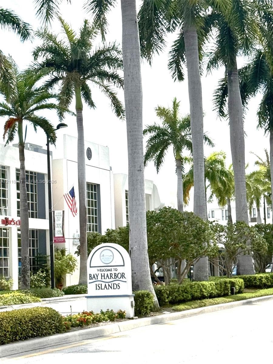 Streetscape featuring mature palm trees, manicured hedges, and professional landscaping