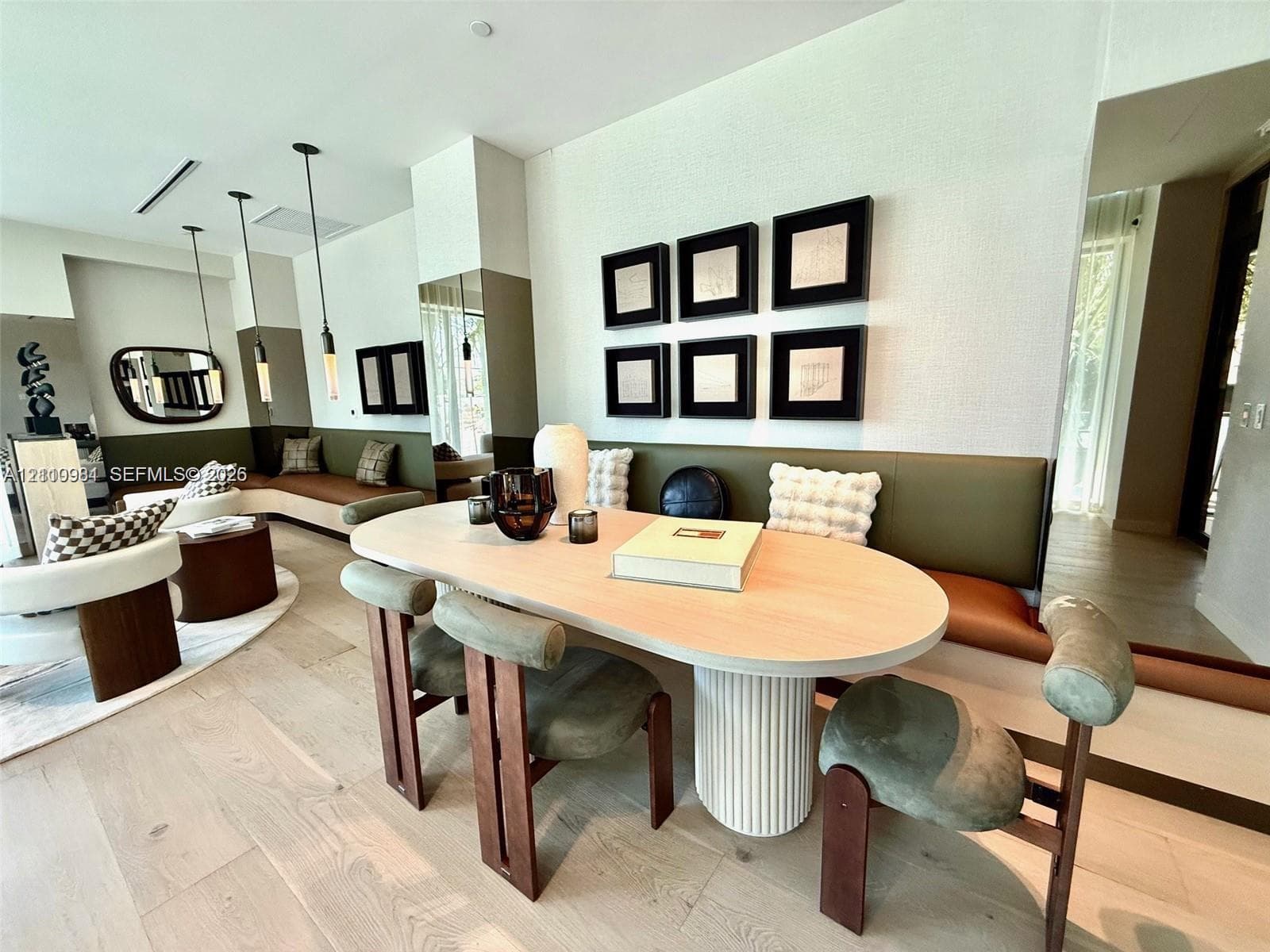 Custom built-in leather banquette seating, wood-finish flooring, and recessed pendant lighting