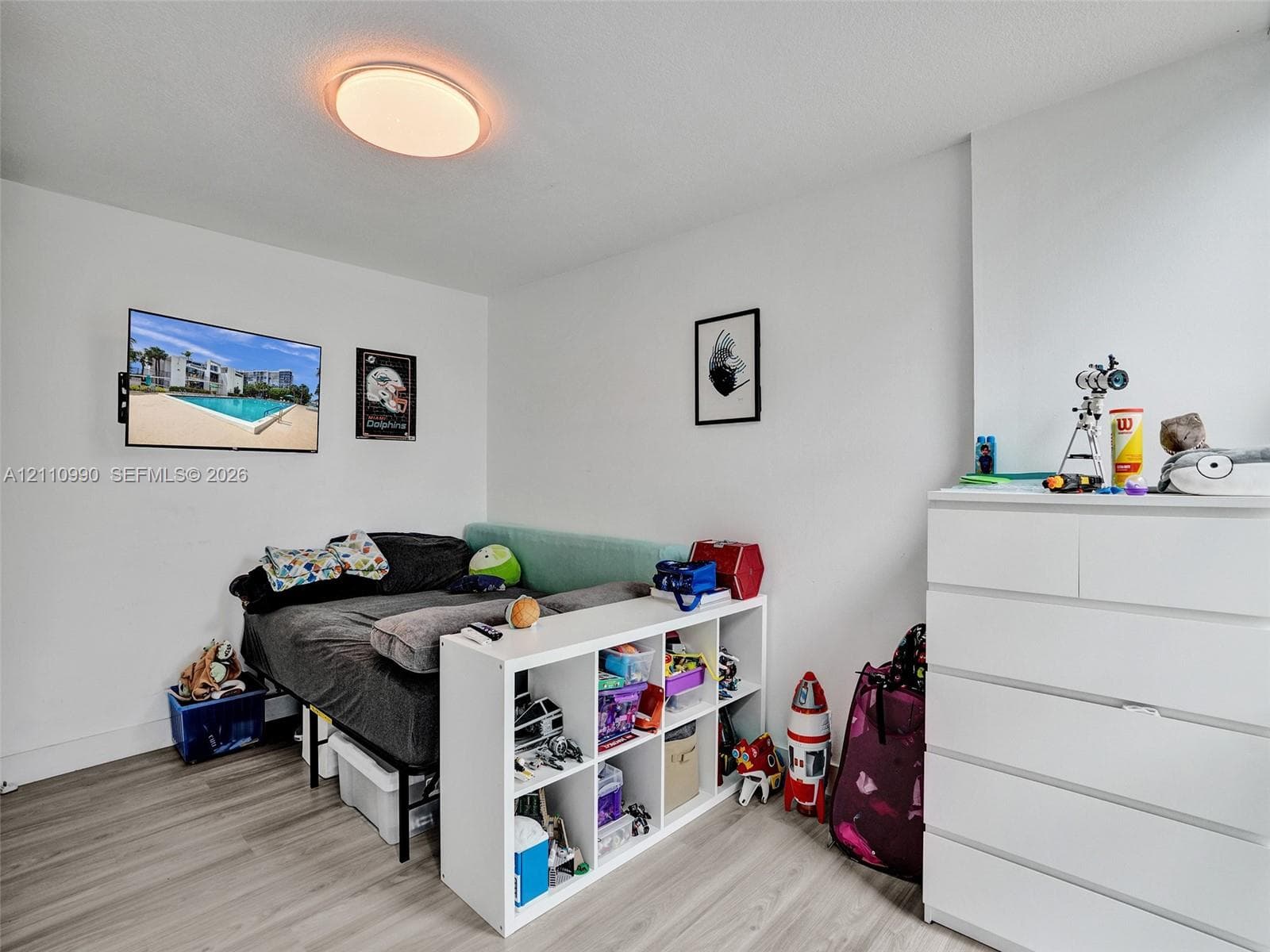 Room featuring neutral wall finishes, wood-finish flooring, and a circular flush-mount ceiling light