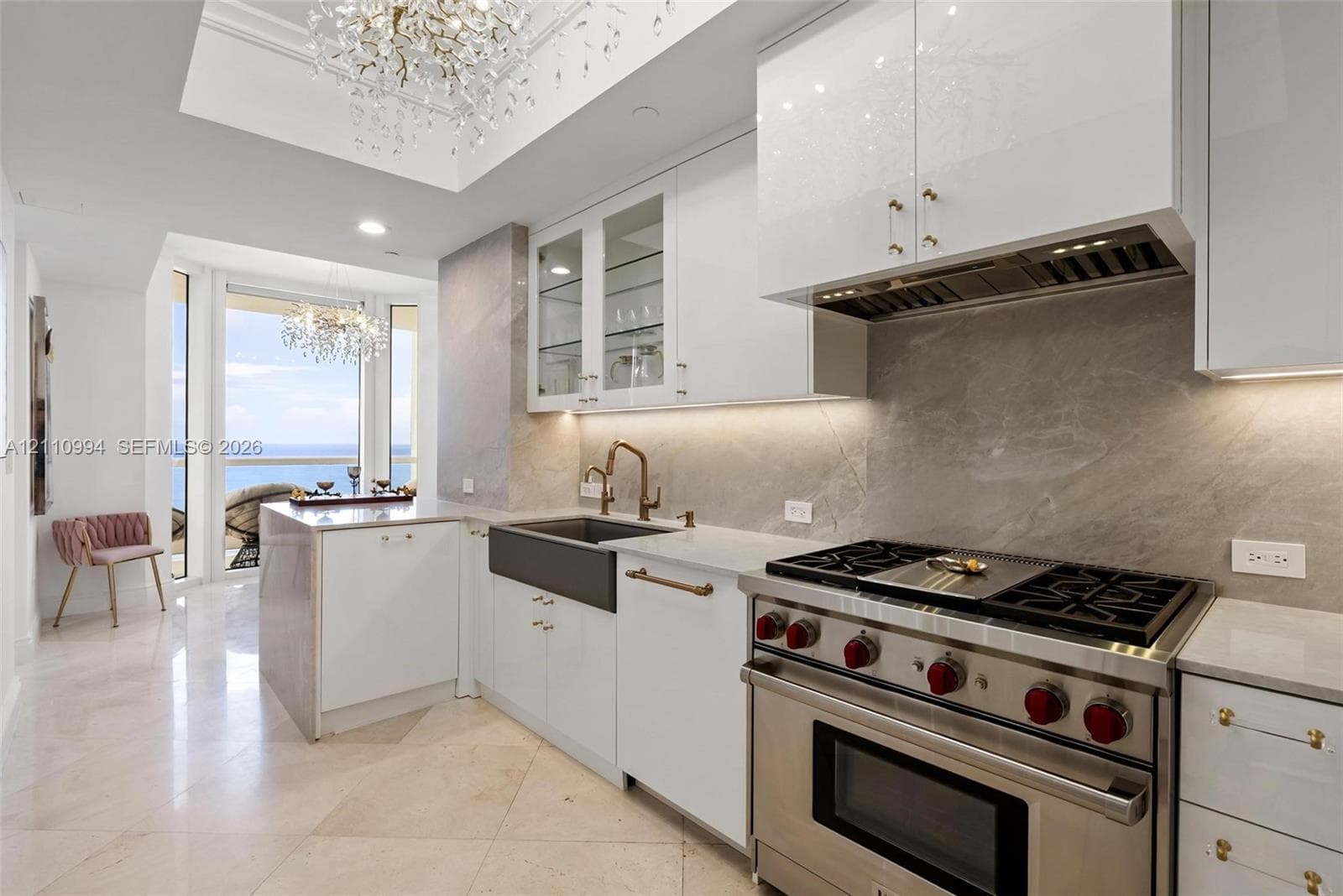 Chef’s kitchen featuring custom white cabinetry, stone slab backsplash, farmhouse-style apron sink, professional-grade stainless steel range, and stone flooring