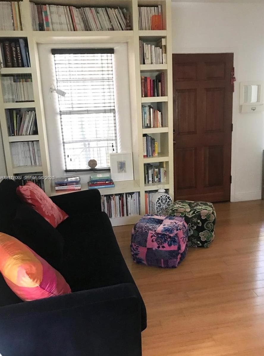 Floor-to-ceiling built-in shelving, wood-finish flooring, and a six-panel wood door