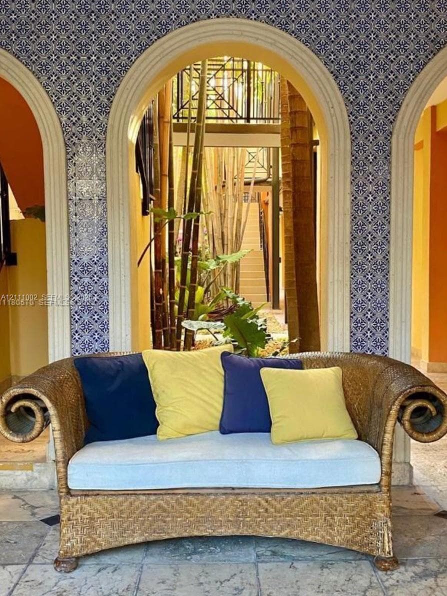 Architectural archways featuring decorative blue and white tile detailing, stone flooring, and metal railing accents
