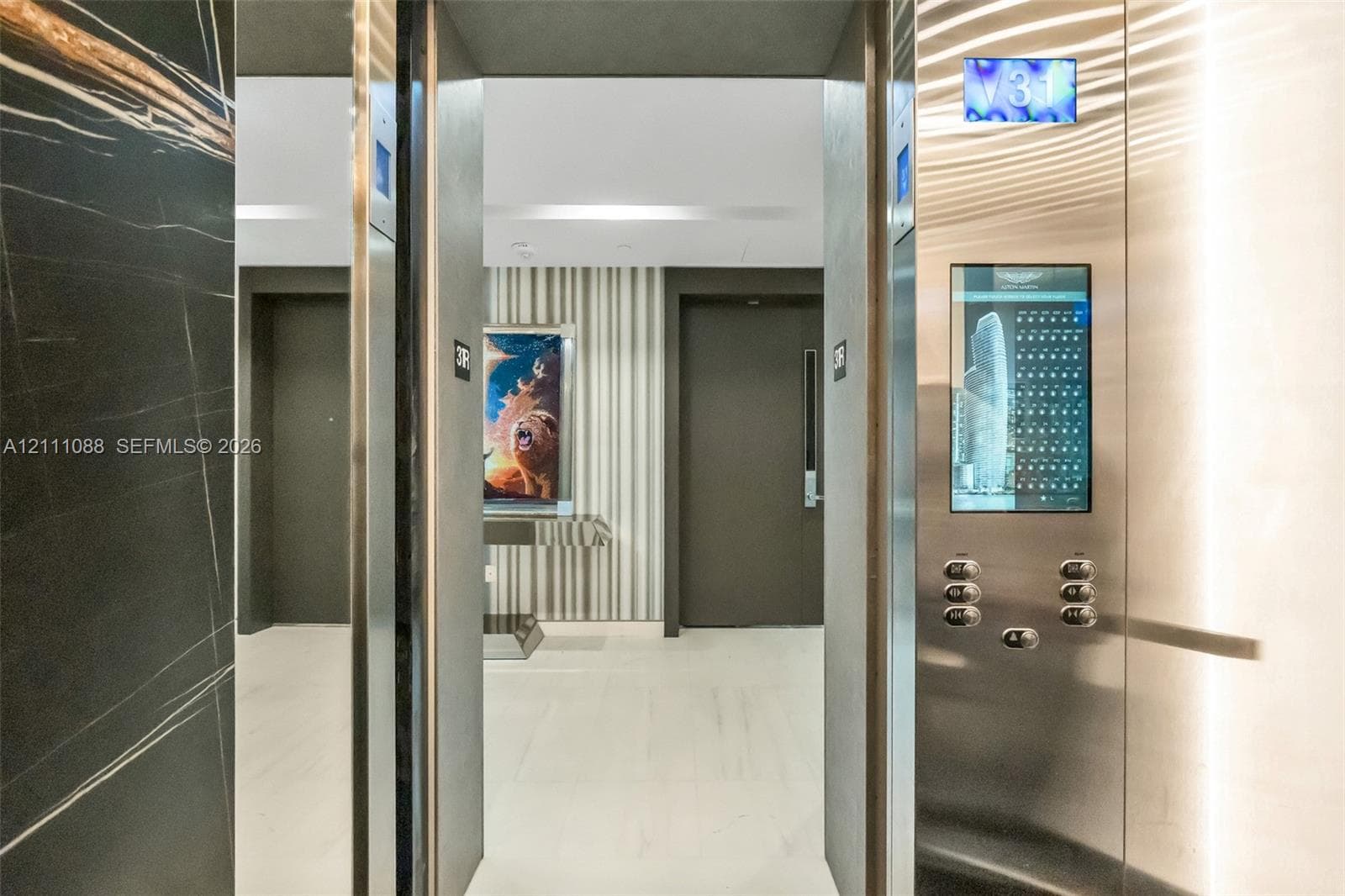 Elevator featuring brushed stainless steel finishes, a digital interface, and interior dark stone wall cladding