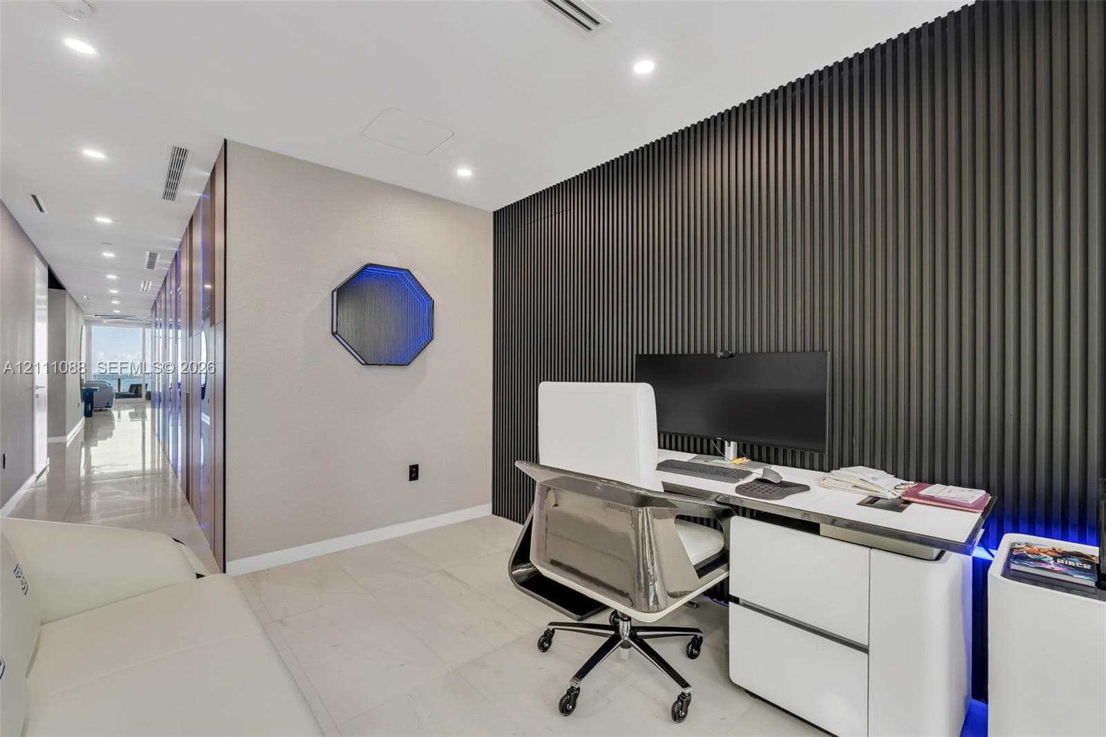 Interior space featuring large-format tile flooring, a floor-to-ceiling ribbed accent wall, and recessed LED ceiling lighting