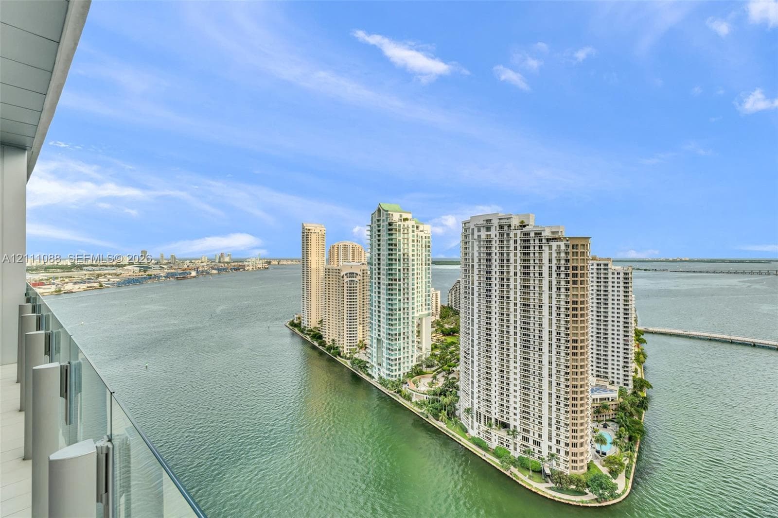 Covered balcony featuring a glass panel railing and panoramic water-facing exposure