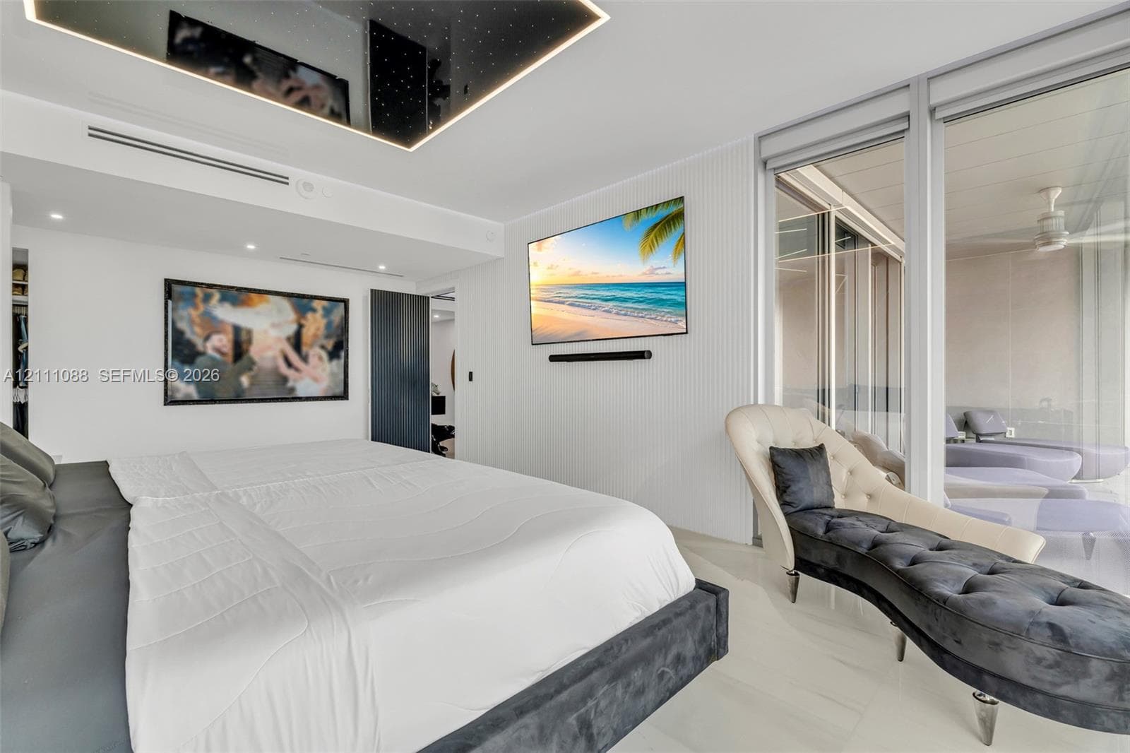 Custom coffered ceiling with integrated recessed lighting, vertical wall paneling, floor-to-ceiling glass sliding doors, and polished stone flooring