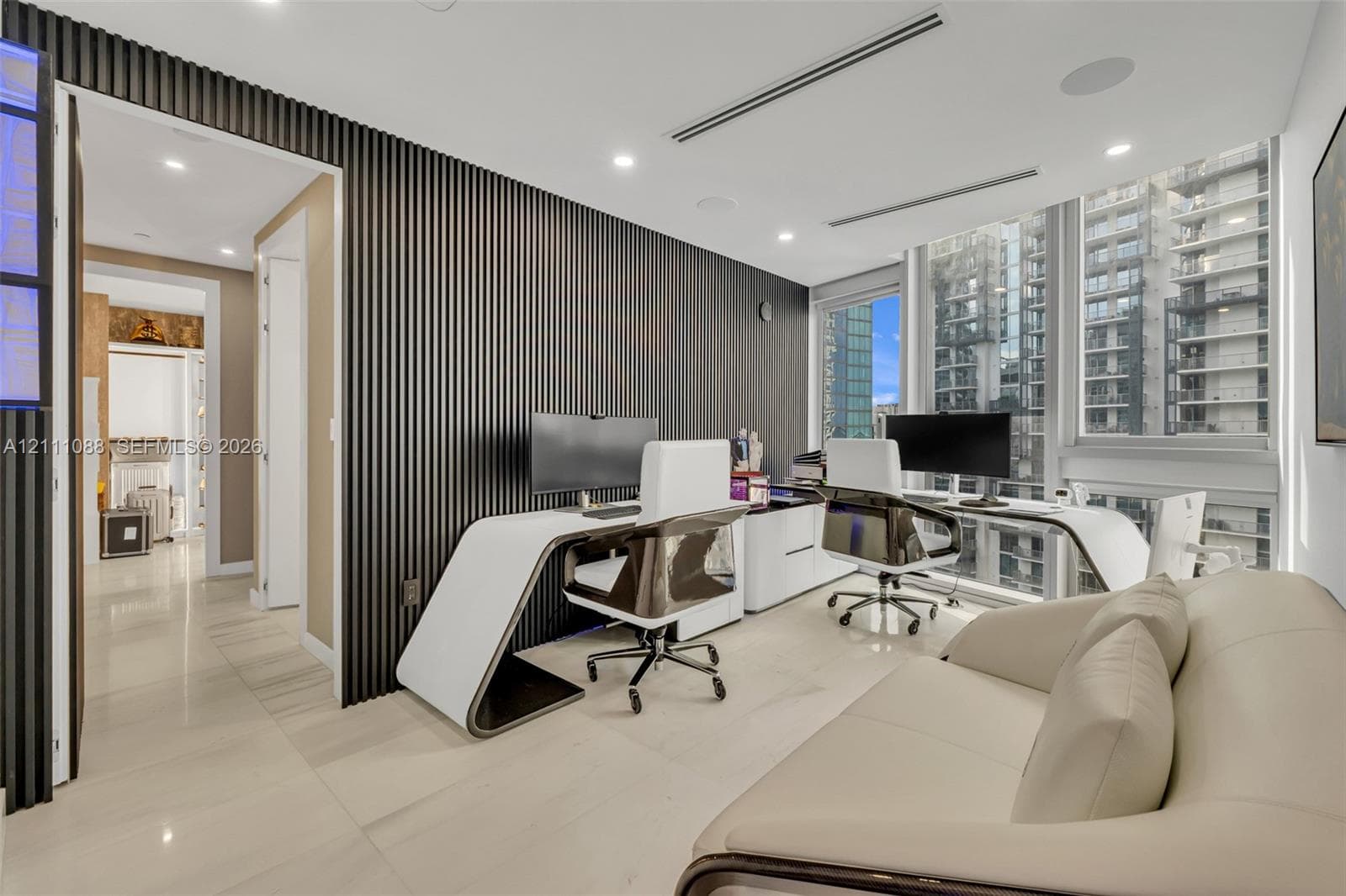 Floor-to-ceiling windows, dark wood-slat accent wall, recessed lighting, and large-format tile flooring