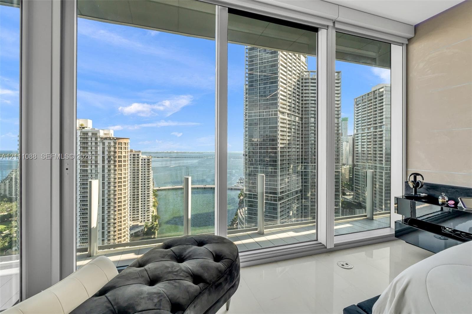 Floor-to-ceiling windows, white tile flooring, and integrated balcony access with glass railings