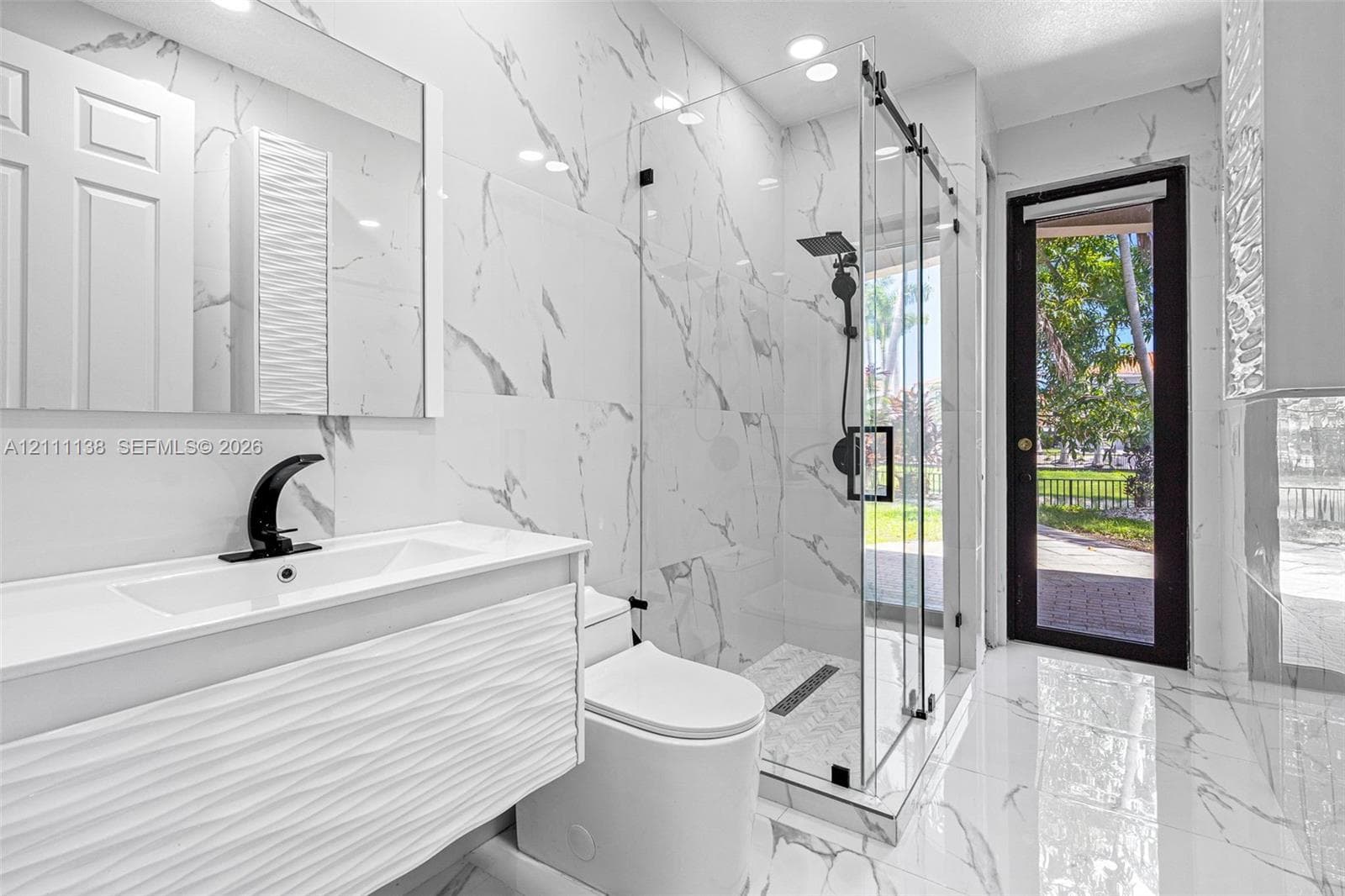 Bathroom featuring floor-to-ceiling porcelain tile, a glass-enclosed walk-in shower with matte black fixtures, a textured vanity cabinet, and a recessed medicine cabinet