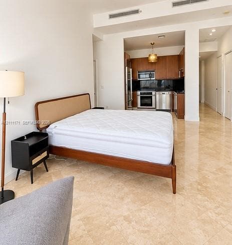 Polished stone flooring, custom wood cabinetry, stainless steel kitchen appliances, and recessed ceiling lighting
