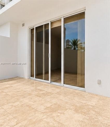 Large-format stone tile flooring complemented by floor-to-ceiling sliding glass doors with metallic frames and neutral wall finishes