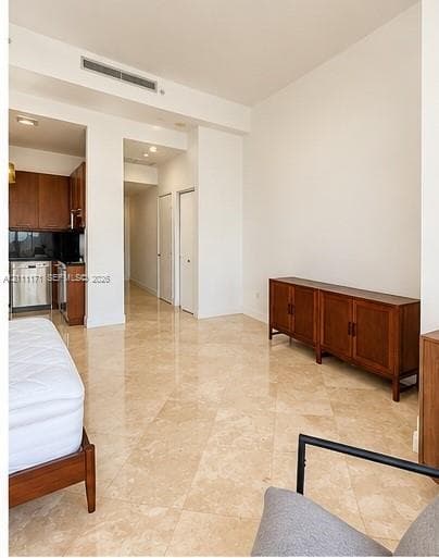 Polished stone flooring, high ceilings with recessed lighting, and kitchen cabinetry with integrated stainless steel appliances