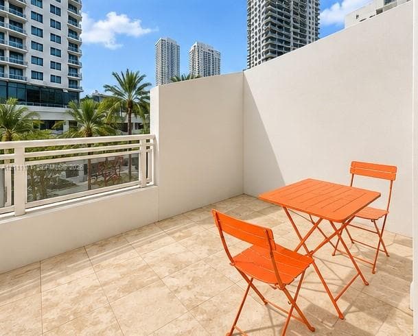 Private balcony featuring stone tile flooring and a horizontal-slat metal railing