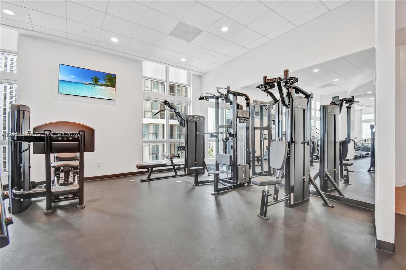 Fitness center featuring rubberized flooring, floor-to-ceiling windows, recessed lighting, and mirrored walls