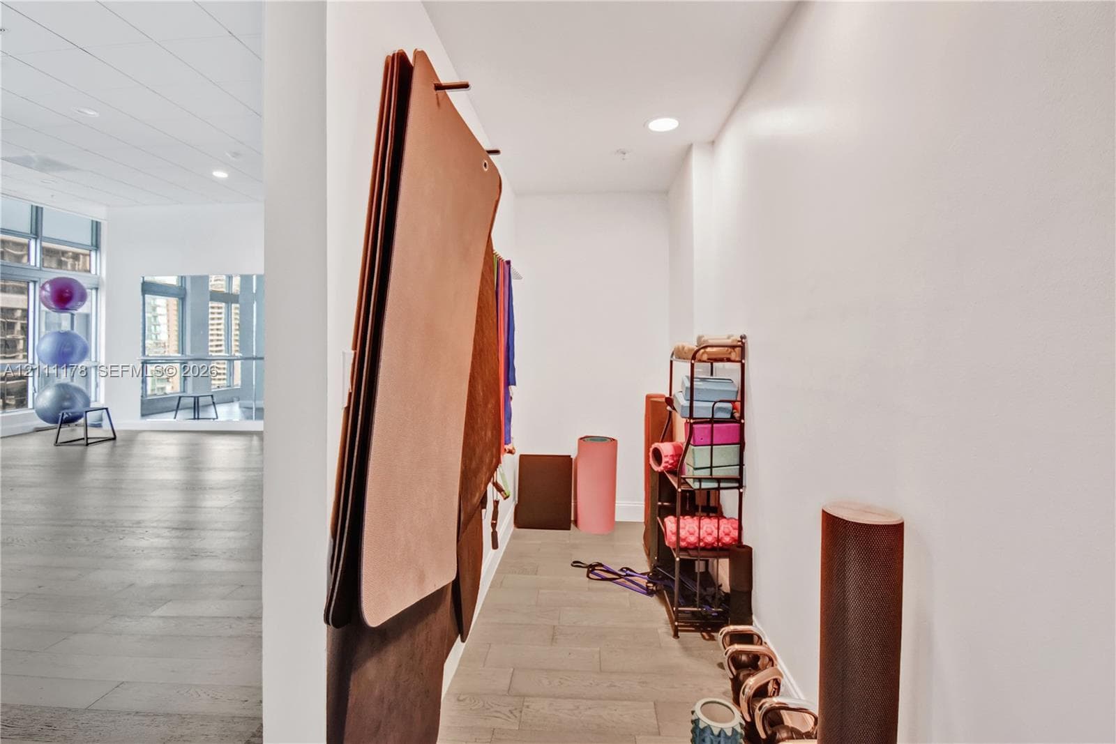 Wood-finish flooring, recessed lighting, and expansive floor-to-ceiling windows