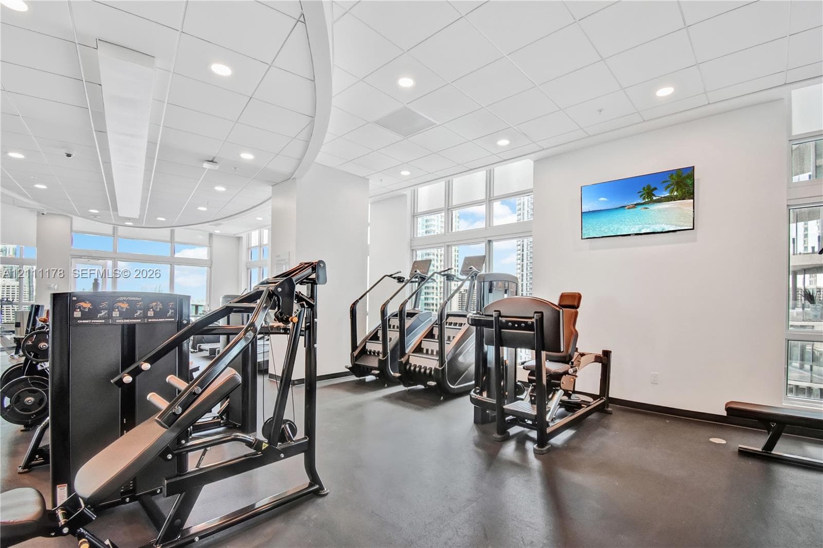 Fitness area featuring expansive floor-to-ceiling windows, recessed ceiling lighting, and smooth-finish flooring