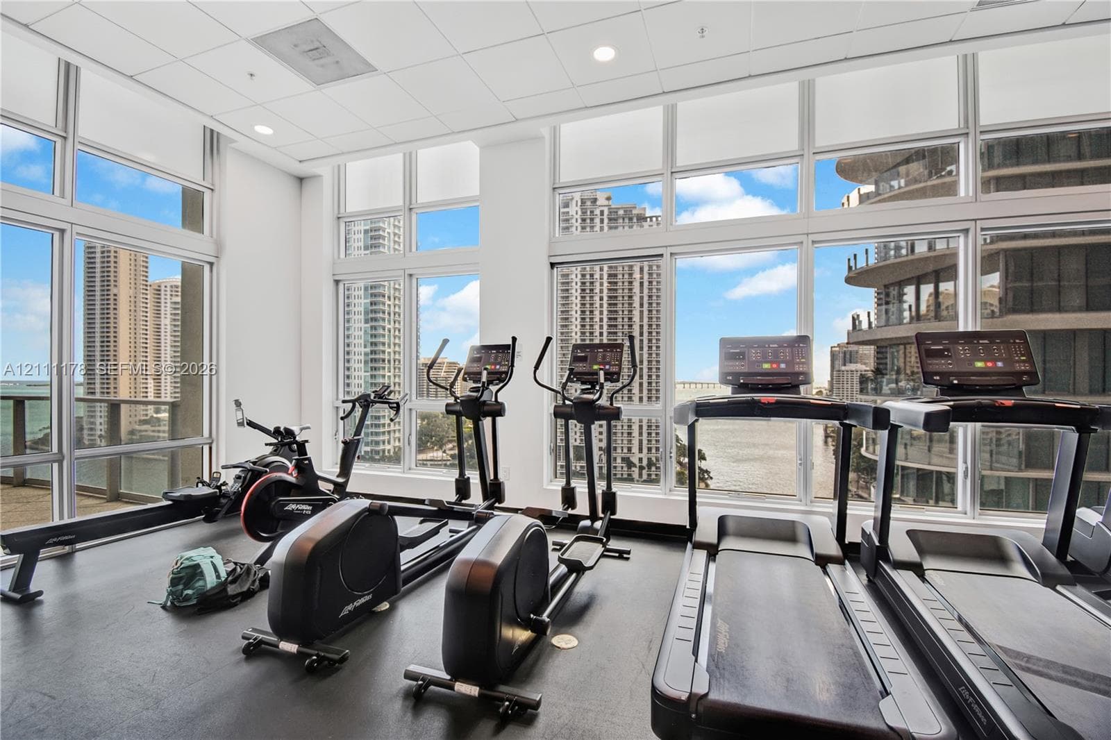 Fitness facility featuring floor-to-ceiling windows, rubberized flooring, and recessed ceiling lighting