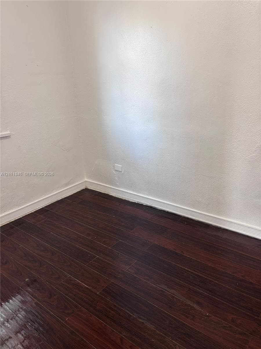 Room featuring wood-finish flooring and neutral painted walls
