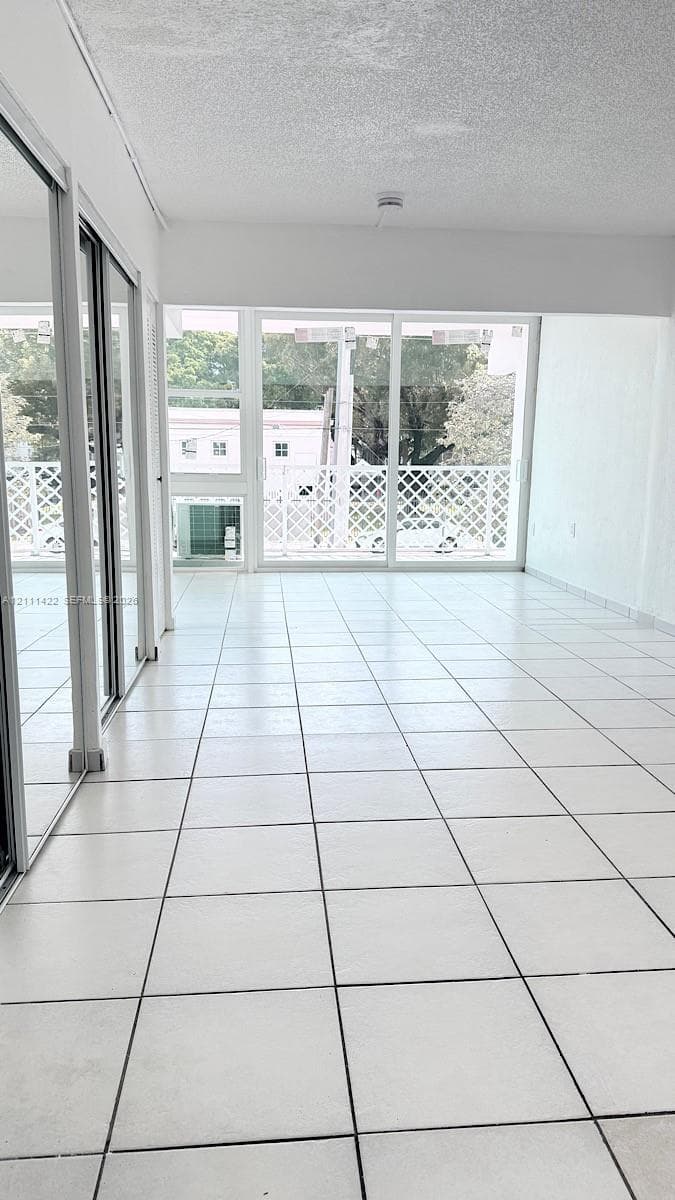 Large-format floor tile, floor-to-ceiling glass sliding doors, and decorative latticework exterior balcony railings