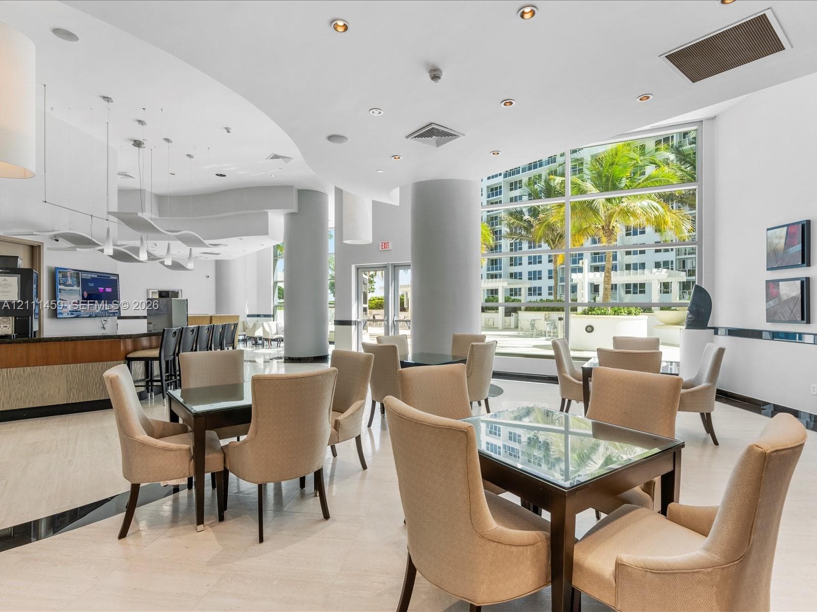 Common area featuring polished stone flooring, floor-to-ceiling windows, recessed lighting, and a built-in refreshment bar