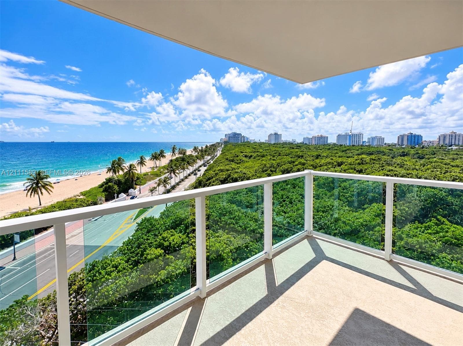 Private balcony featuring glass-panel railings and a neutral-toned hard surface floor