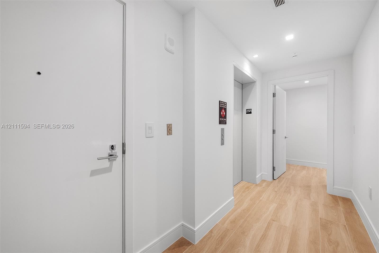Interior hallway featuring wood-finish flooring, recessed lighting, and a dedicated elevator entrance