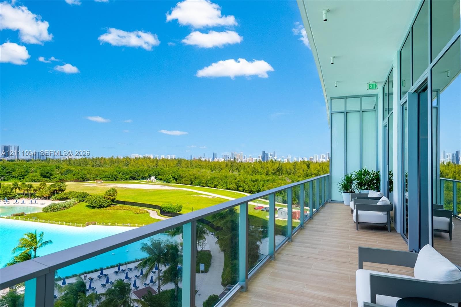 Covered balcony featuring wood-finish flooring, full-height glass panel railings, and floor-to-ceiling glass wall panels